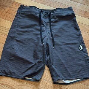 Grey Volcom board shorts.